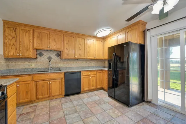 a kitchen with stainless steel appliances granite countertop a refrigerator and a sink