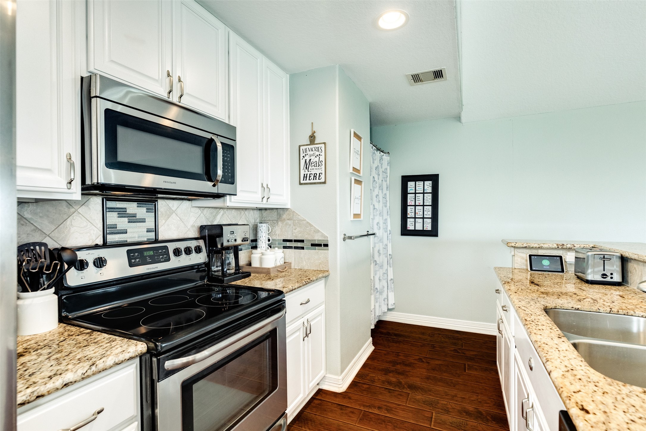 16547 Jolly Roger Road Jamaica Beach, TX 77554 - Photo 22 of 27 a kitchen with stainless steel appliances granite countertop a stove and a microwave