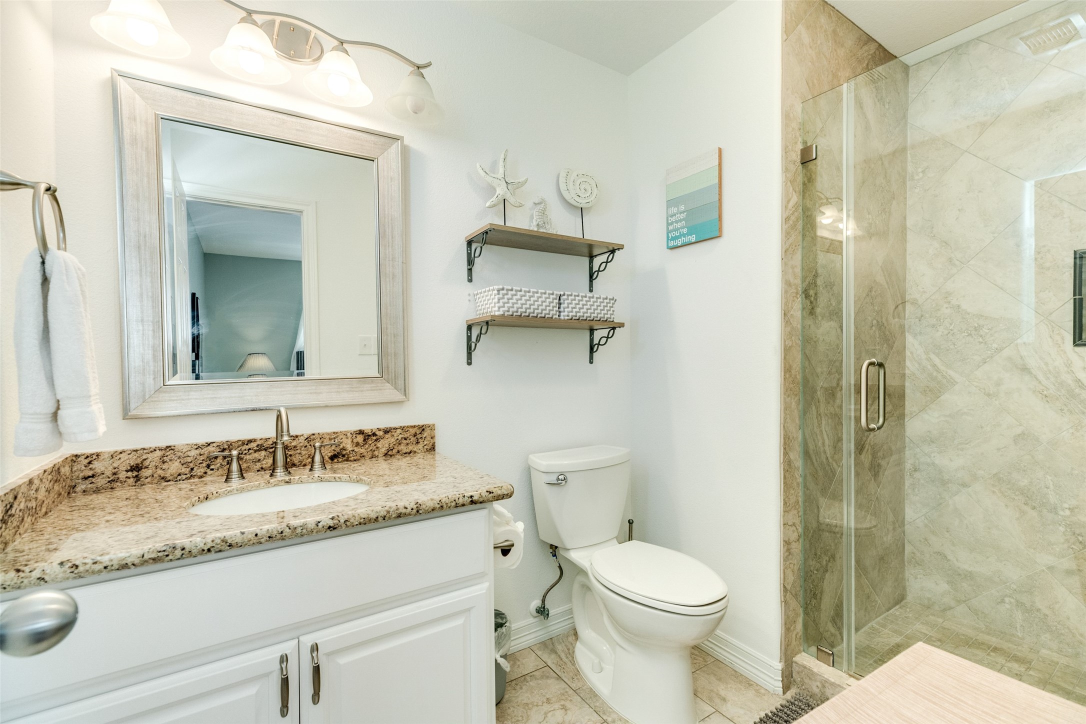 16547 Jolly Roger Road Jamaica Beach, TX 77554 - Photo 24 of 27 a bathroom with a granite countertop sink toilet and shower