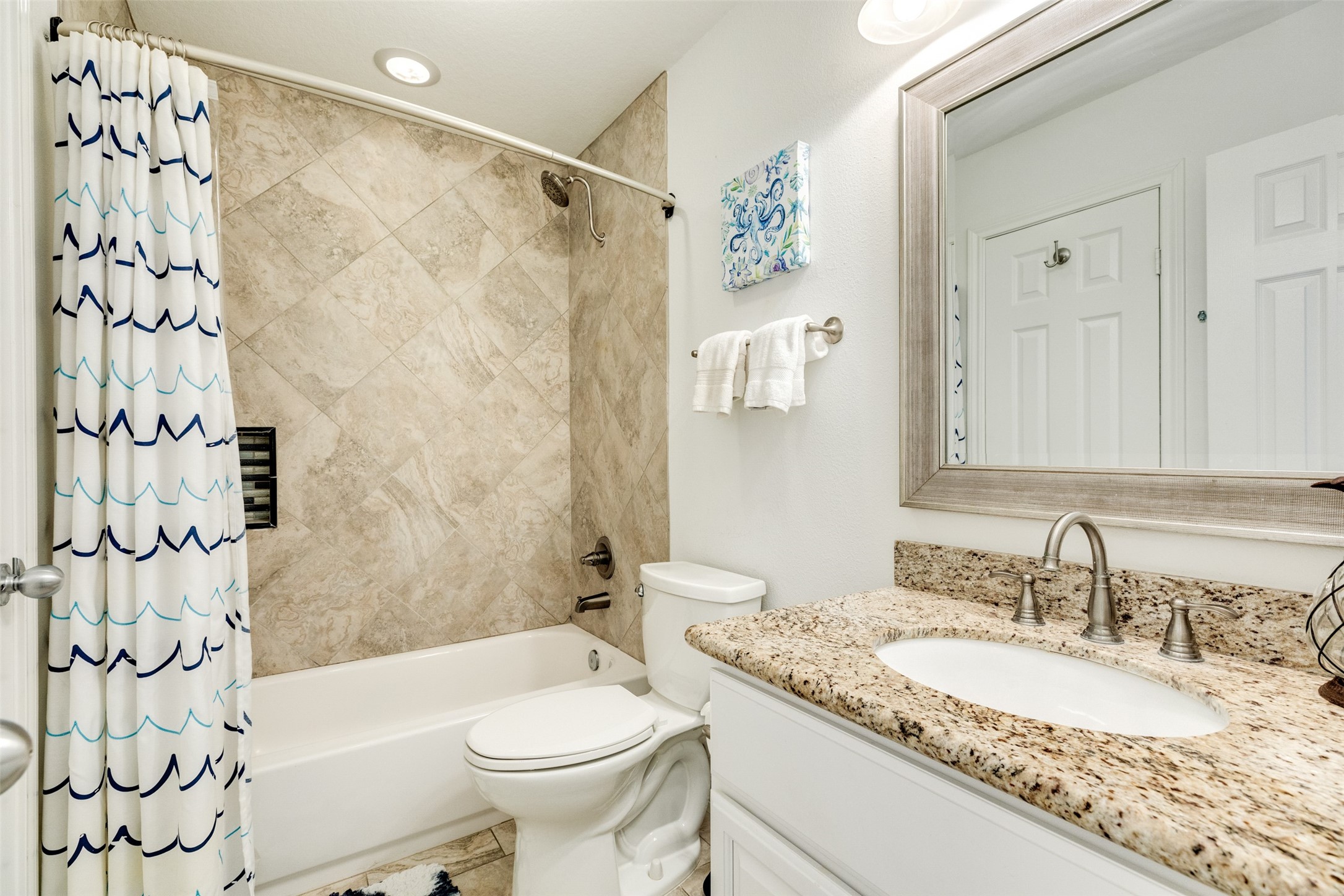 16547 Jolly Roger Road Jamaica Beach, TX 77554 - Photo 27 of 27 a bathroom with a granite countertop sink a toilet a mirror a bathtub and shower