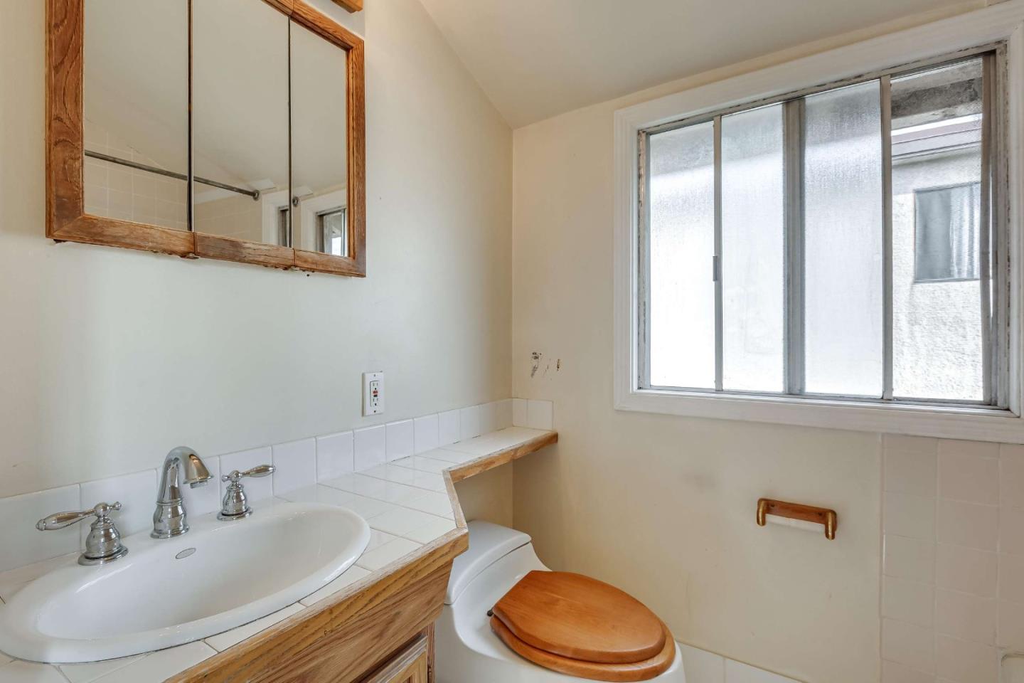 230 Victoria Road Burlingame, CA 94010 - Photo 64 of 69 a bathroom with a sink a toilet and a mirror