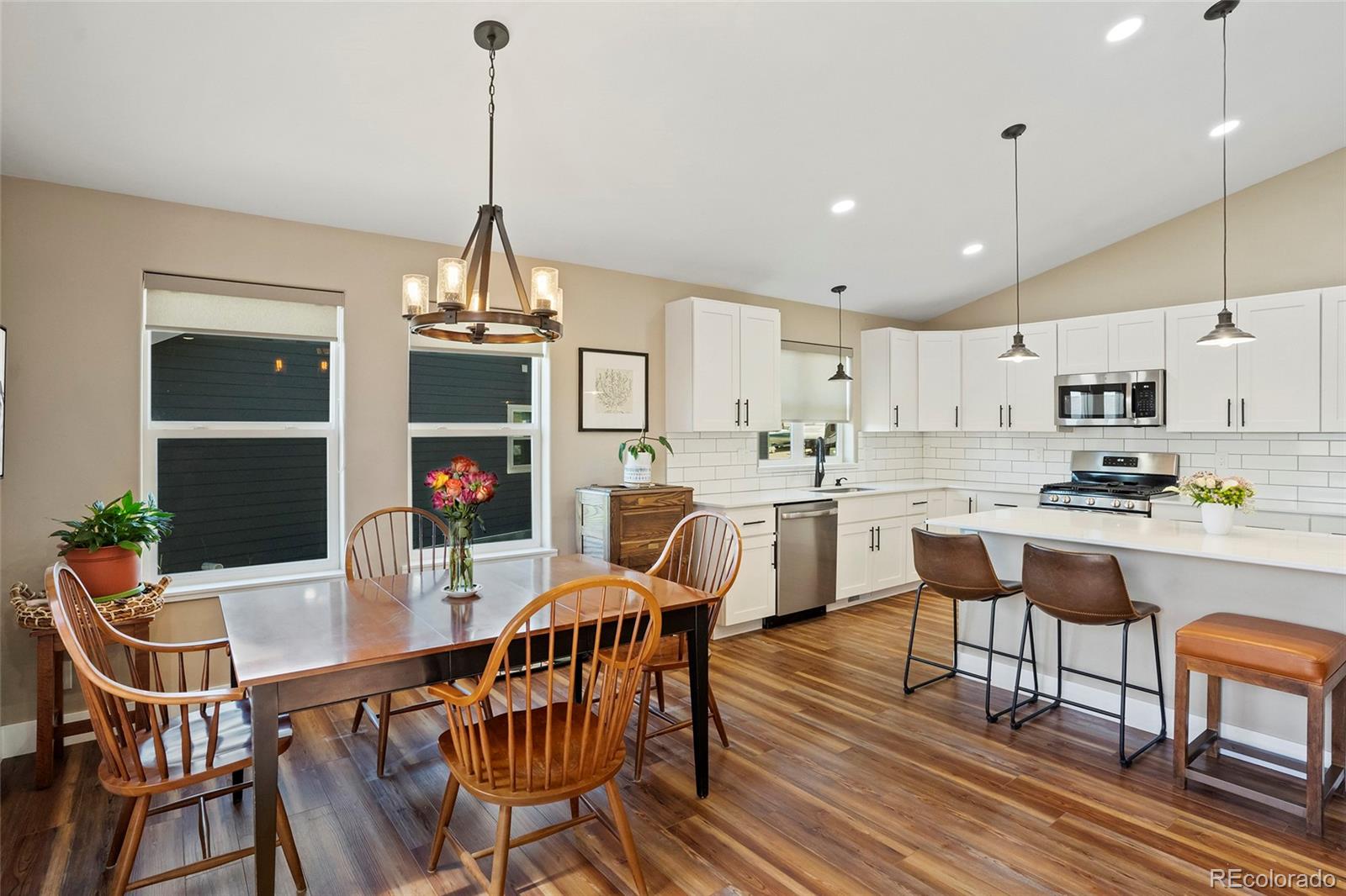 365 Lake View Road Hayden, CO 81639 - Photo 4 of 24 a kitchen with stainless steel appliances kitchen island granite countertop a dining table chairs and white cabinets