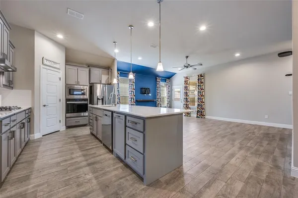 a kitchen with kitchen island a sink stainless steel appliances and cabinets