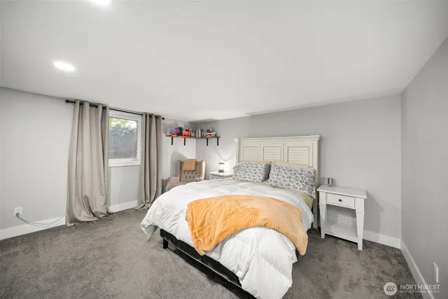 a bed sitting in a room next to a lamp