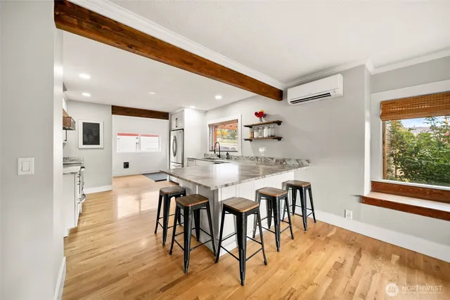 a kitchen with stainless steel appliances kitchen island granite countertop a table chairs and a refrigerator