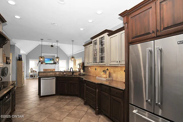 a kitchen with stainless steel appliances granite countertop a refrigerator a sink and dishwasher