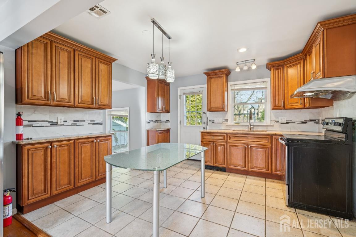 25 Reed Street Edison, NJ 08817 - Photo 4 of 23 a kitchen with stainless steel appliances granite countertop a stove a sink dishwasher and a refrigerator with wooden cabinets