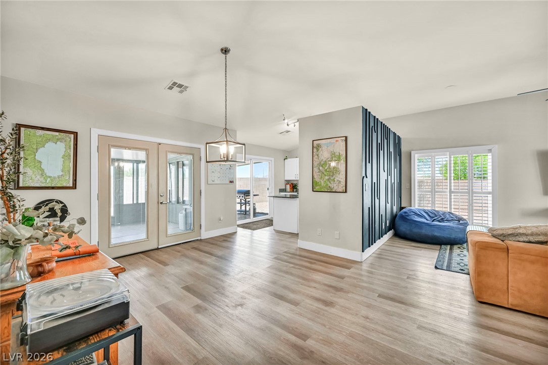 1234 Sunfire Street Henderson, NV 89014 - Photo 6 of 40 Natural light cascades across a fluid open-concept living area with durable flooring and modern architectural details.