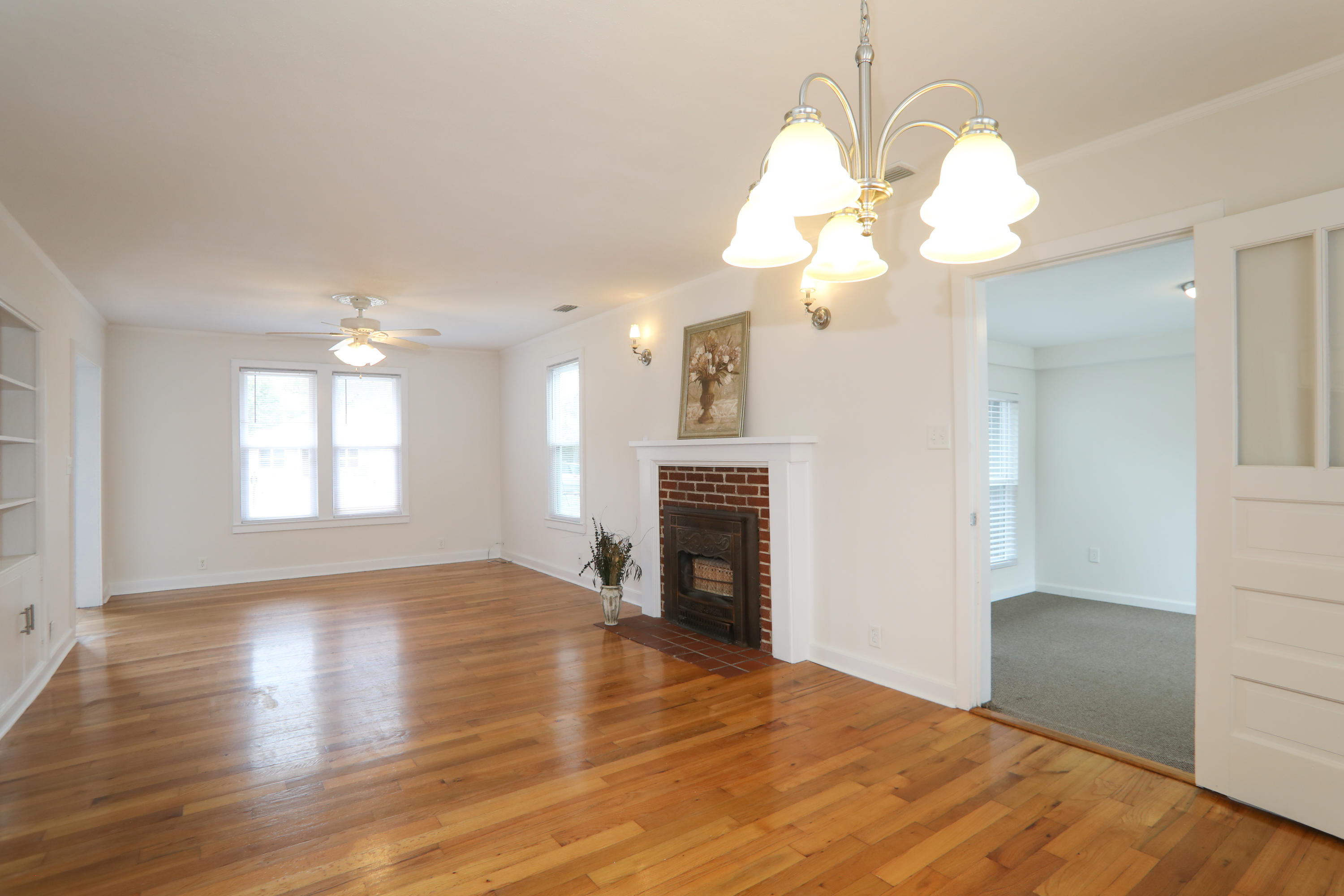 302 East 2nd Avenue Crestview, FL 32536 - Photo 4 of 12 a view of an empty room with wooden floor fireplace and a window