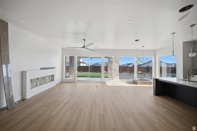 3011 East Rimrunner Drive, Unit 302 St. George, UT 84790 - Photo 9 of 45 Unfurnished living room featuring light wood-type flooring, a fireplace, and ceiling fan