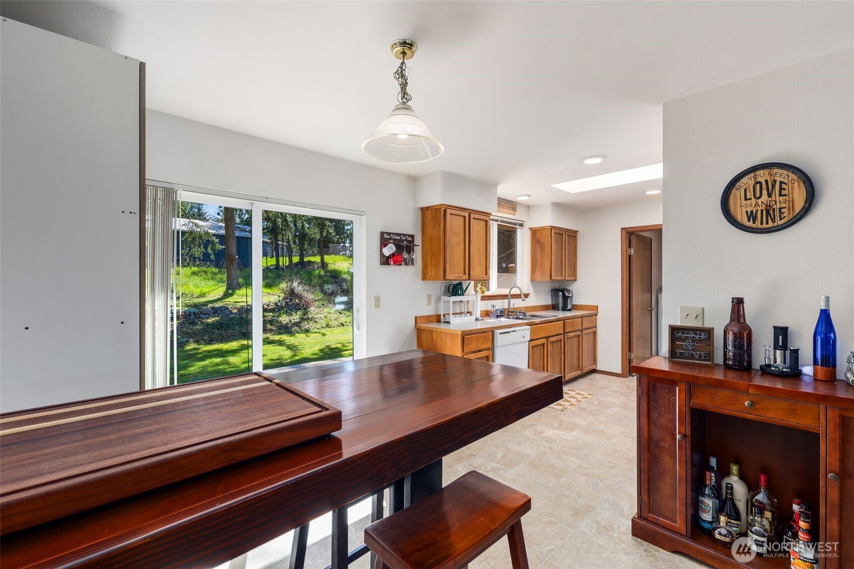 22424 South Prairie Road East Bonney Lake, WA 98391 - Photo 14 of 32 a kitchen with a stove a refrigerator and a dining table with wooden floor