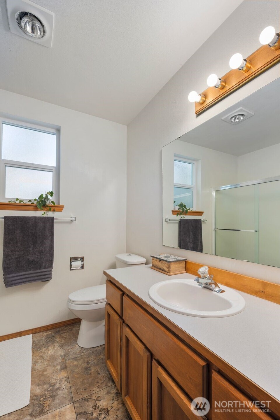 22424 South Prairie Road East Bonney Lake, WA 98391 - Photo 19 of 32 a bathroom with a sink a toilet a mirror and shower