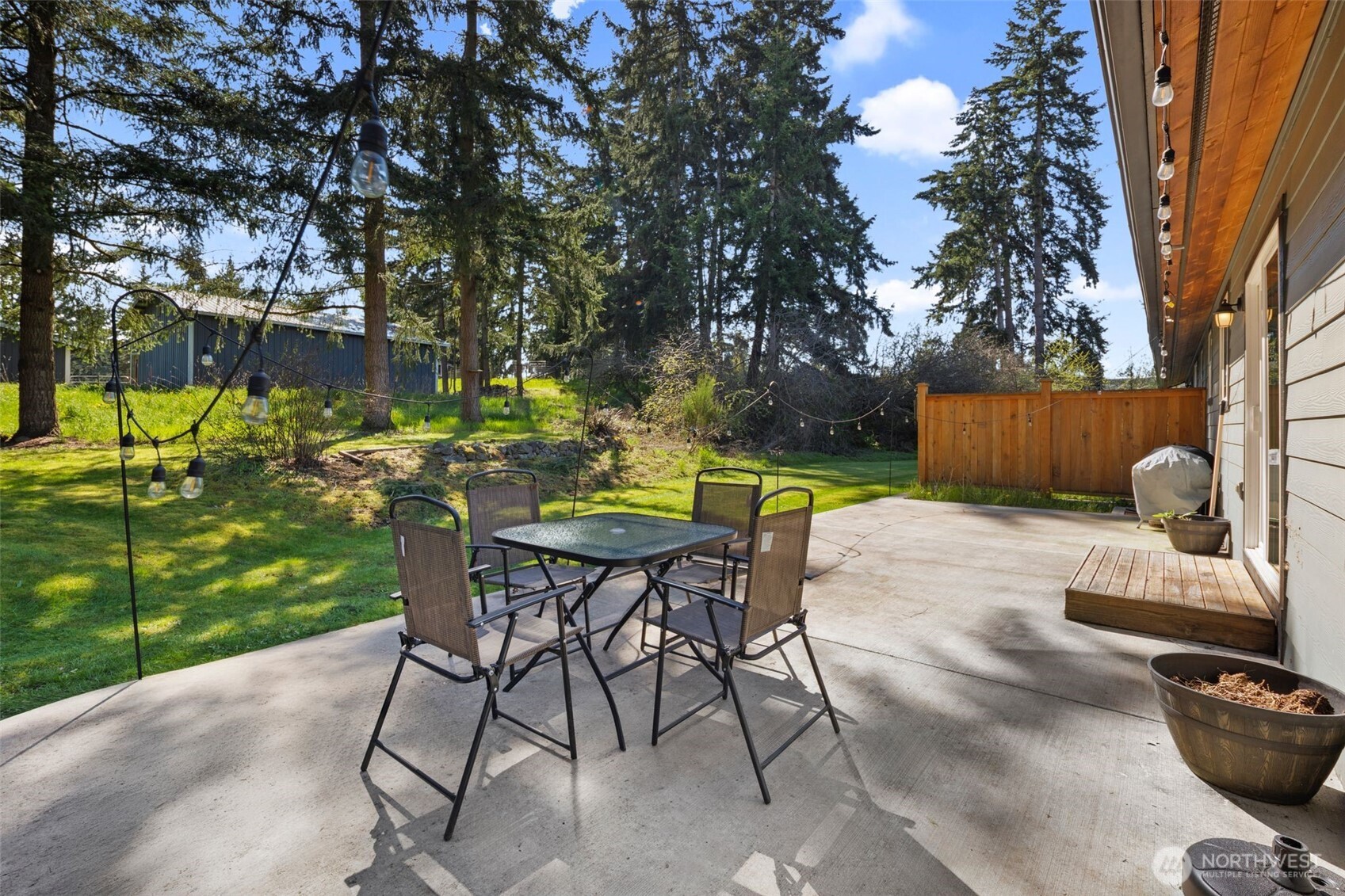 22424 South Prairie Road East Bonney Lake, WA 98391 - Photo 26 of 32 a view of a backyard with table and chairs potted plants and a large tree
