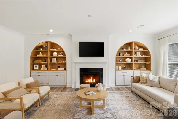 a living room with furniture a fireplace and a flat screen tv