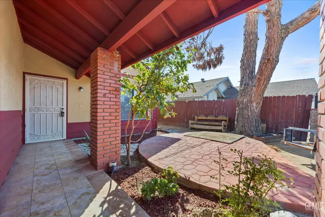 a patio with table and chairs with wooden fence