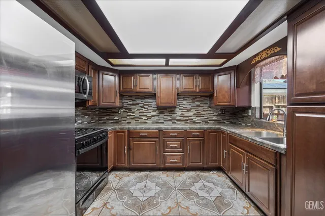 a kitchen with stainless steel appliances granite countertop a sink stove and cabinets