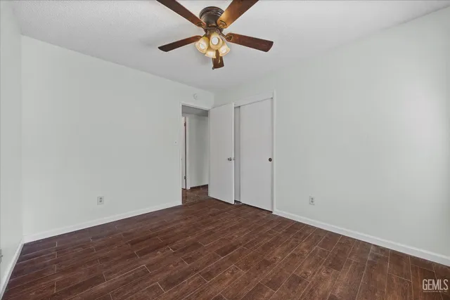 a view of room with a ceiling fan and wooden floor