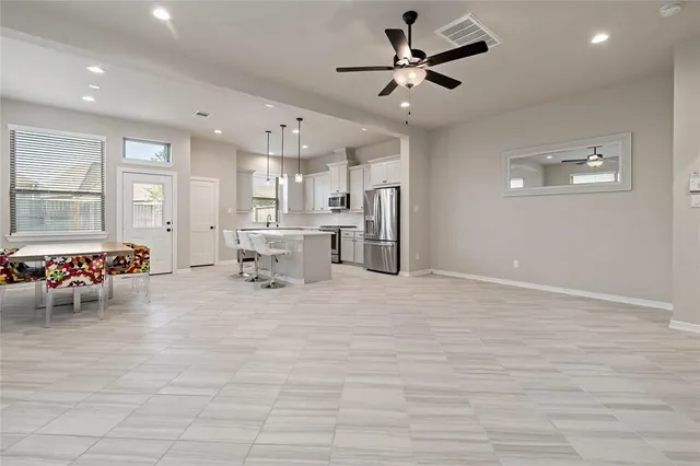 a view of a livingroom with furniture a ceiling fan and window
