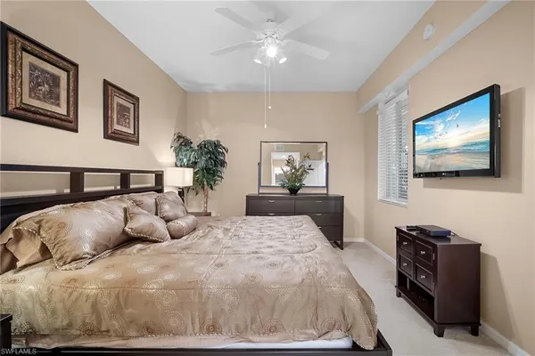 a bedroom with a large bed and a flat screen tv