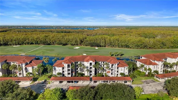 an aerial view of a house with a yard and lake view