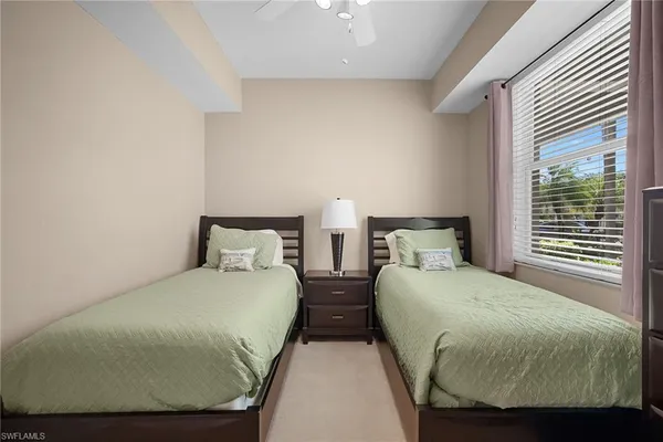 a bedroom with two beds and windows