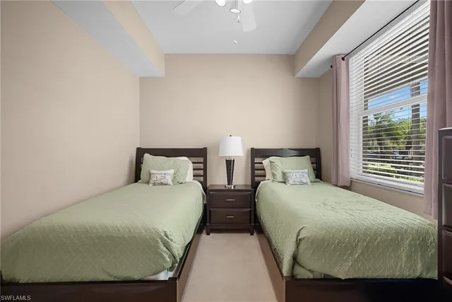 a bedroom with two beds and windows