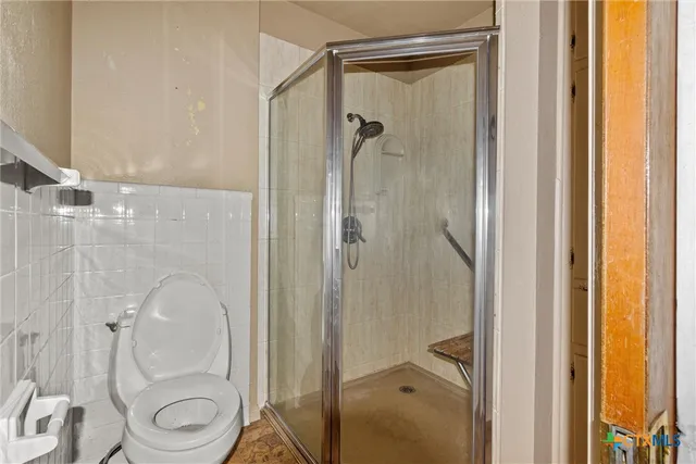 a bathroom with a granite countertop shower mirror and toilet