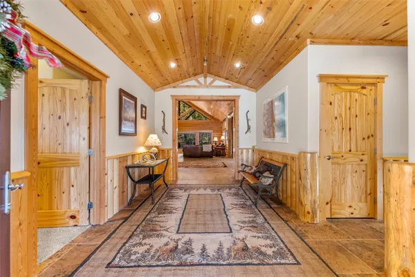 a hallway with white doors wooden floor and a chandelier