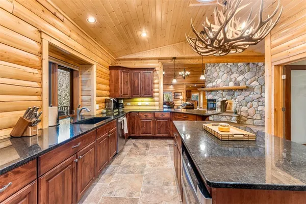 a large kitchen with stainless steel appliances granite countertop a lot of counter space and a sink