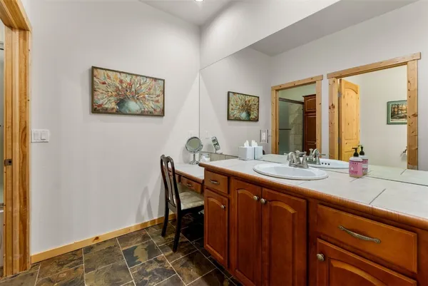 a spacious bathroom with a granite countertop sink a mirror and a bathtub