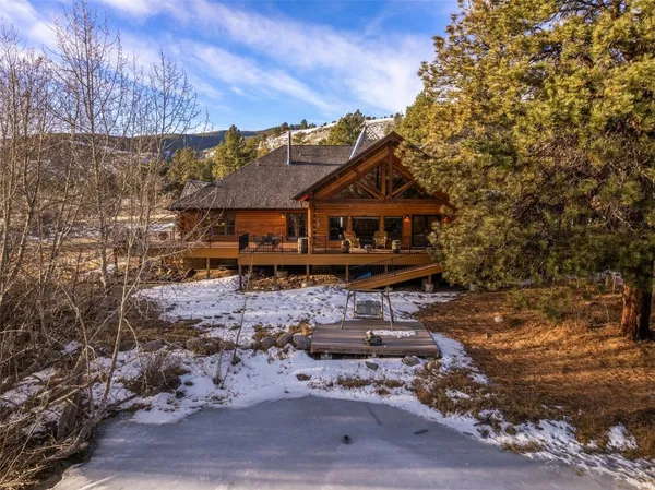 a view of a big house with wooden fence