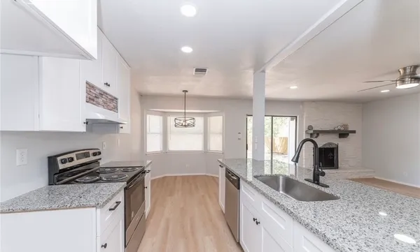 a view of a kitchen with a stove wooden floor and a window