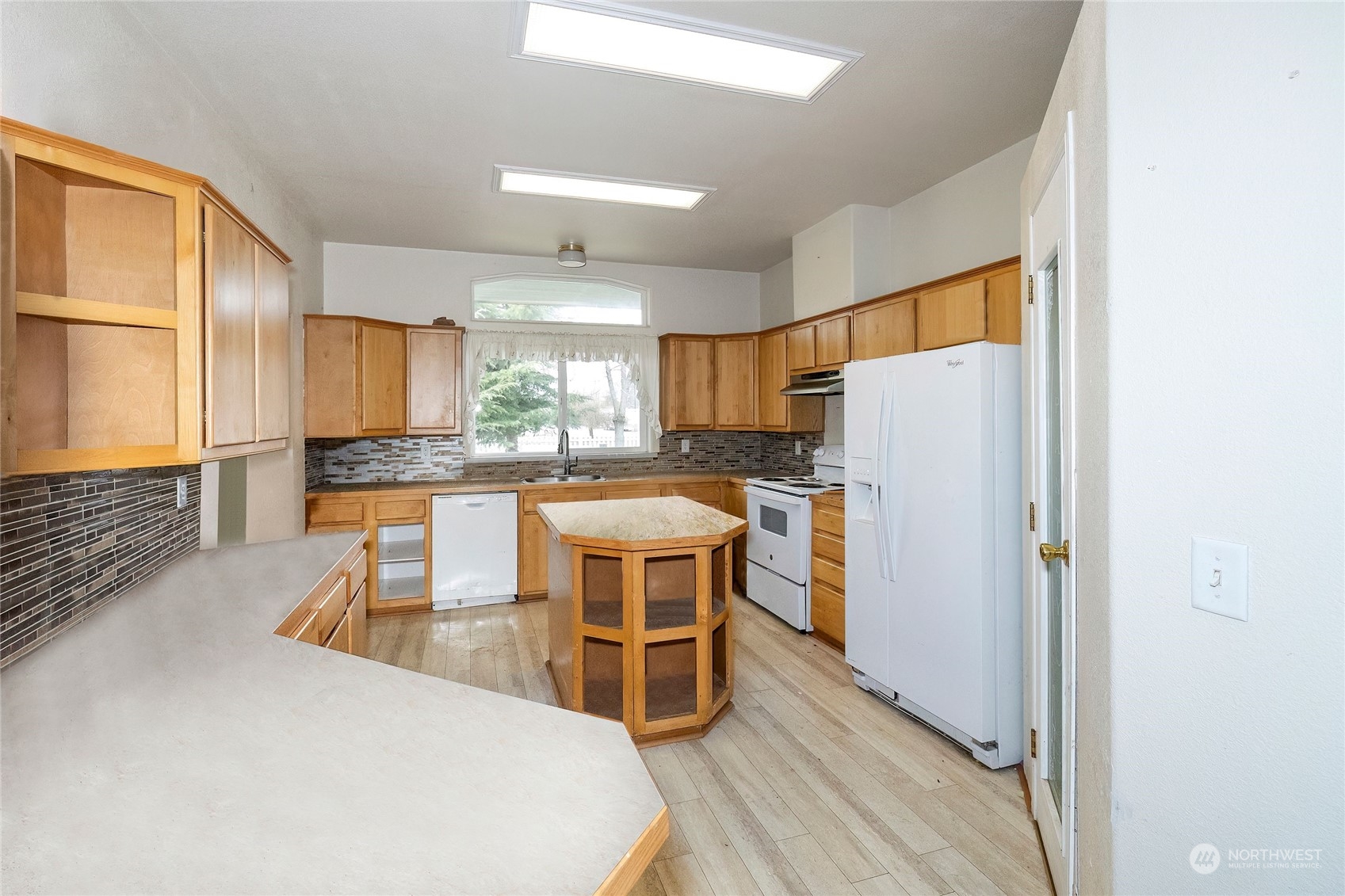 245 Griffith Farm Road Sequim, WA 98382 - Photo 17 of 33 a kitchen with stainless steel appliances granite countertop a refrigerator a sink a stove a dining table and chairs with wooden floor