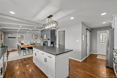 a very nice looking dining room with furniture a chandelier and wooden floor