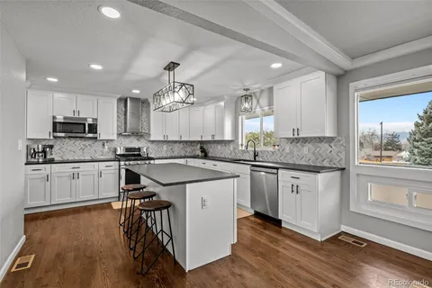 a kitchen with granite countertop white cabinets and white appliances