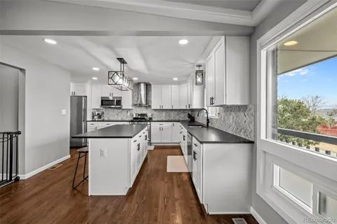 a kitchen with kitchen island a counter top space a sink stainless steel appliances and cabinets