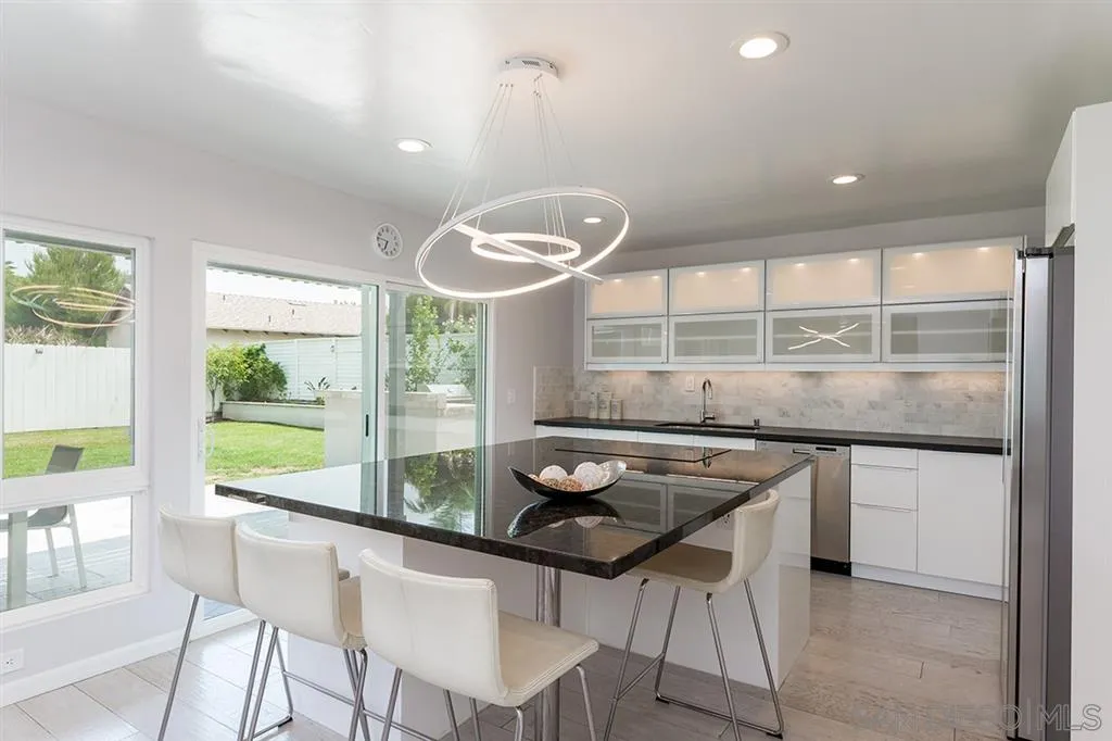 13617 Calais Drive Del Mar, CA 92014 - Photo 9 of 25 a kitchen with a stove a table and chairs in it