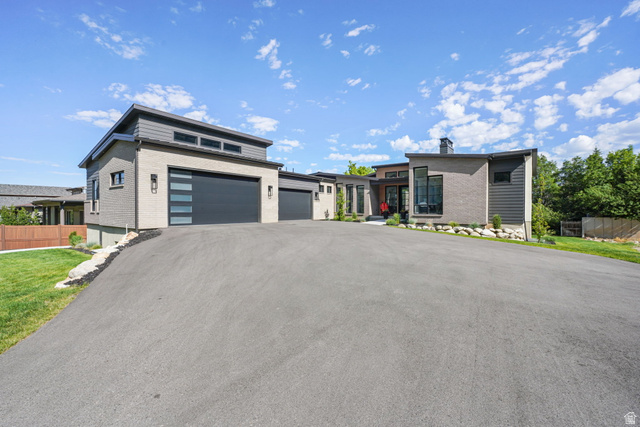 3667 Little Cottonwood Road, Unit 1 Sandy, UT 84092 - Photo 3 of 49 Modern architectural residence featuring a multi-tone exterior, an attached garage with a contemporary door, a large paved driveway, and established landscaping