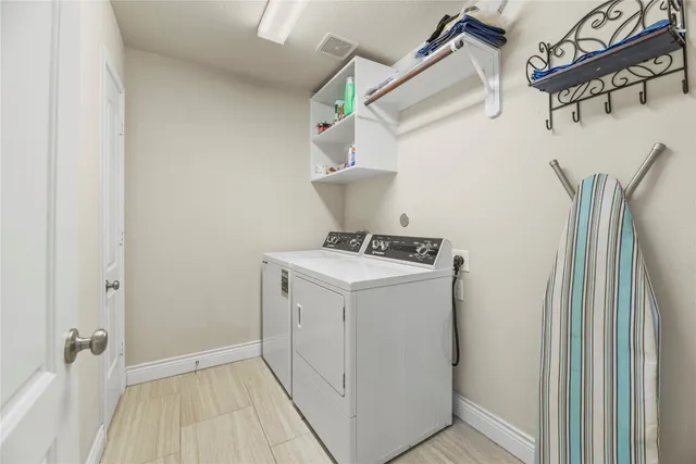 a utility room with cabinets washer and dryer