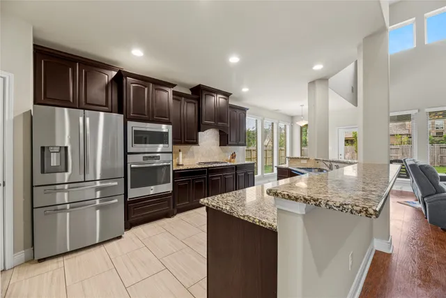 a kitchen with granite countertop a refrigerator and a sink