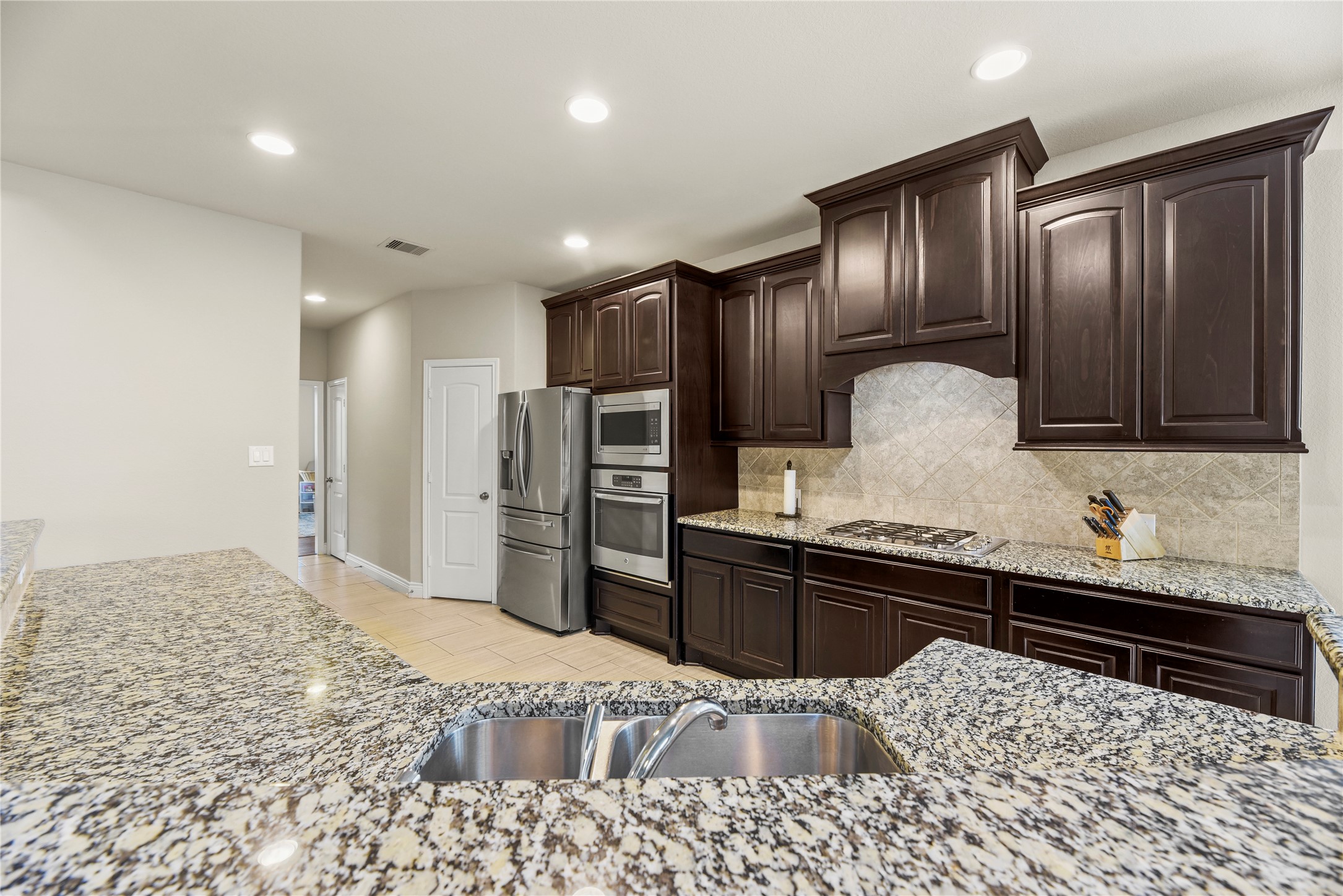 3834 Trophy Ridge Drive Spring, TX 77386 - Photo 15 of 43 a kitchen with granite countertop wooden cabinets and stainless steel appliances