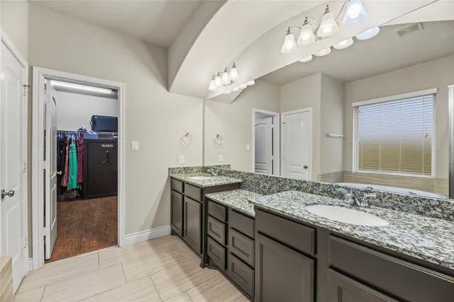 a bathroom with a granite countertop sink a large mirror and a shower