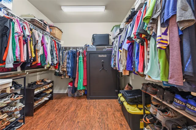 a view of walk in closet with clothes and shoes