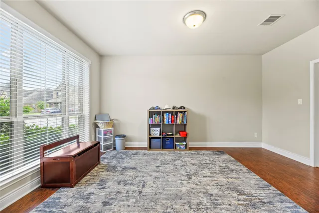 a view of a big room with wooden floor and furniture