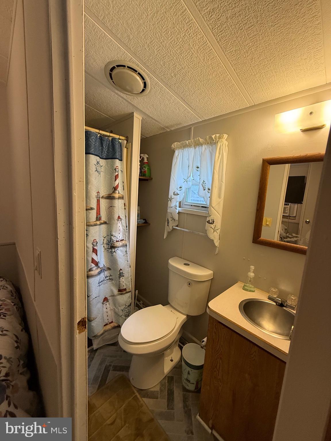 515 Corsons Tavern Road, Unit F32 Ocean View, NJ 08230 - Photo 9 of 16 a white toilet sitting next to a bathroom sink and a shower