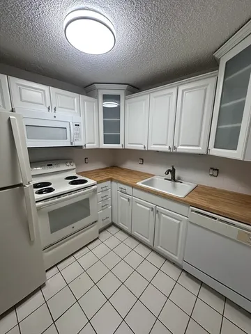 a kitchen with granite countertop a sink stainless steel appliances and cabinets