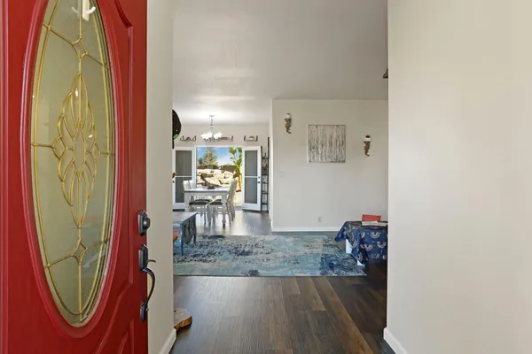 a living room with furniture and a dining table with wooden floor