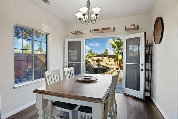 a view of a dining room with furniture a chandelier and wooden floor