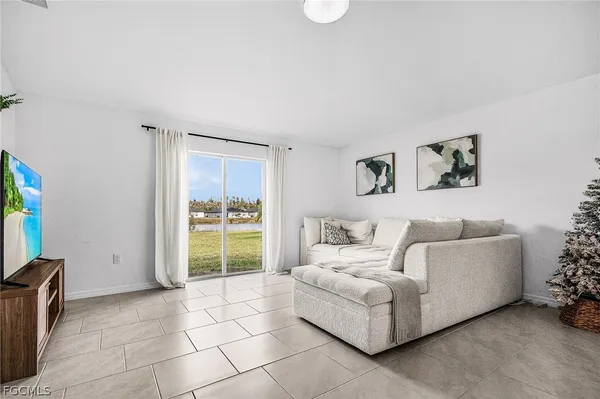 a living room with furniture a flat screen tv and a window