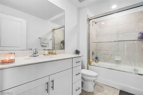a bathroom with a granite countertop sink toilet a mirror and shower